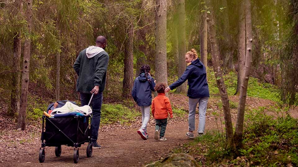 Fotograf: Maskot
Bildbyrå: Johnér Familj med två barn promenerar i skogen och drar en campingvagn efter sig. Sverige
