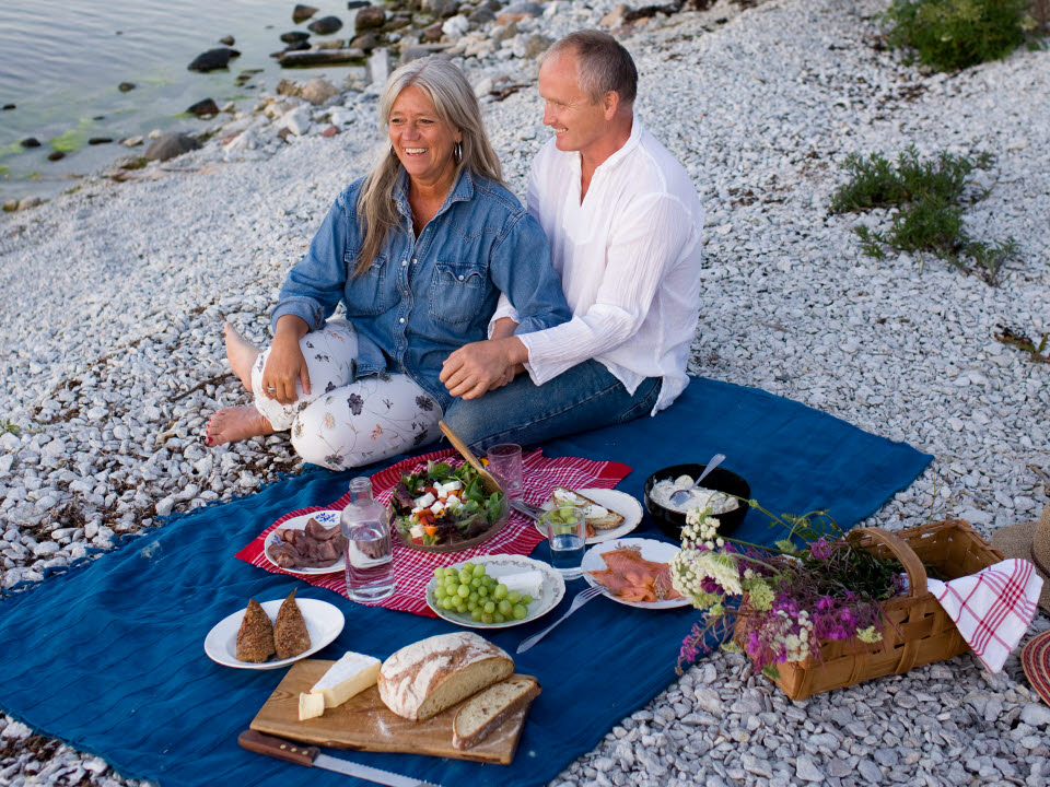Man och kvinna på picknick vid strand, Gotland
