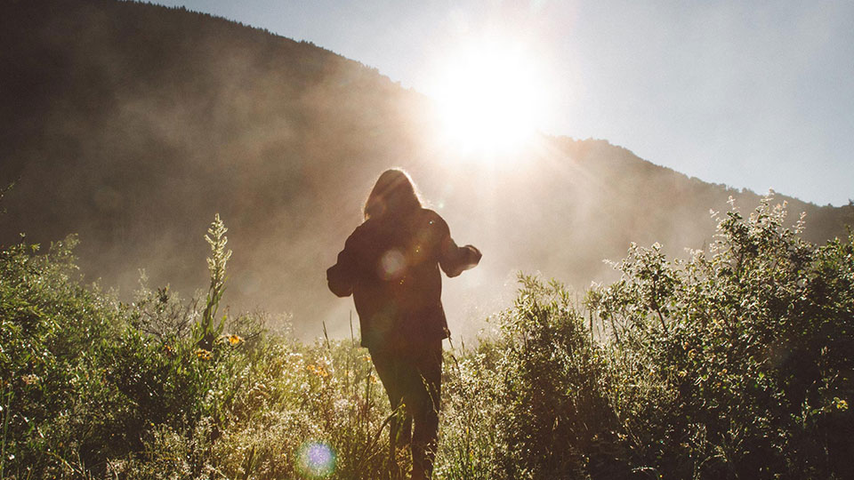 Silhouette of a person walking in the mountains.