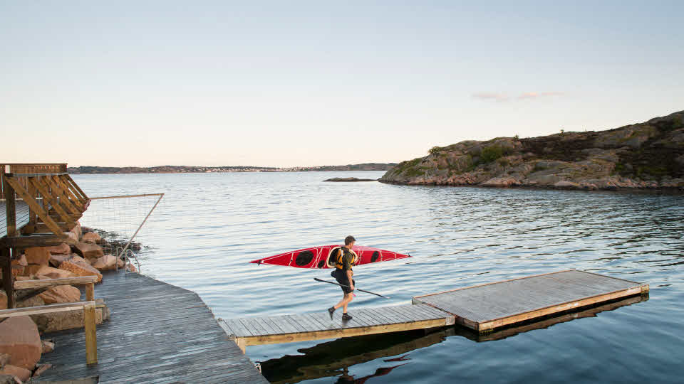 Fotograf: Maskot
Bildbyrå: Johner Man med kajag å axeln går på en brygga vid havet