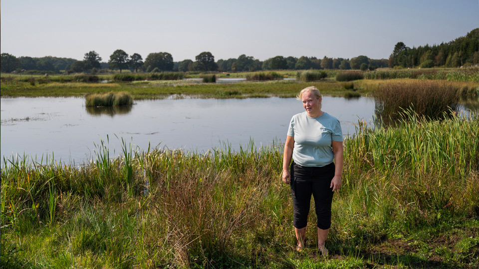 Fotograf: Lina Alriksson Kvinna framför sjö på ängsmark
