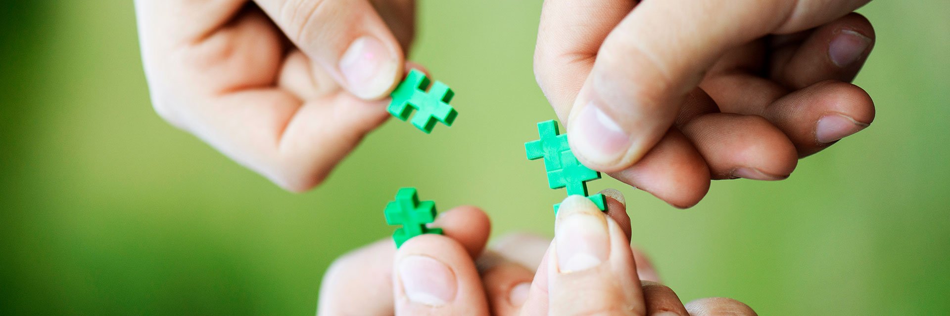 Samarbete, händer sträcker fram gröna pusselbitar.Christina Sundien