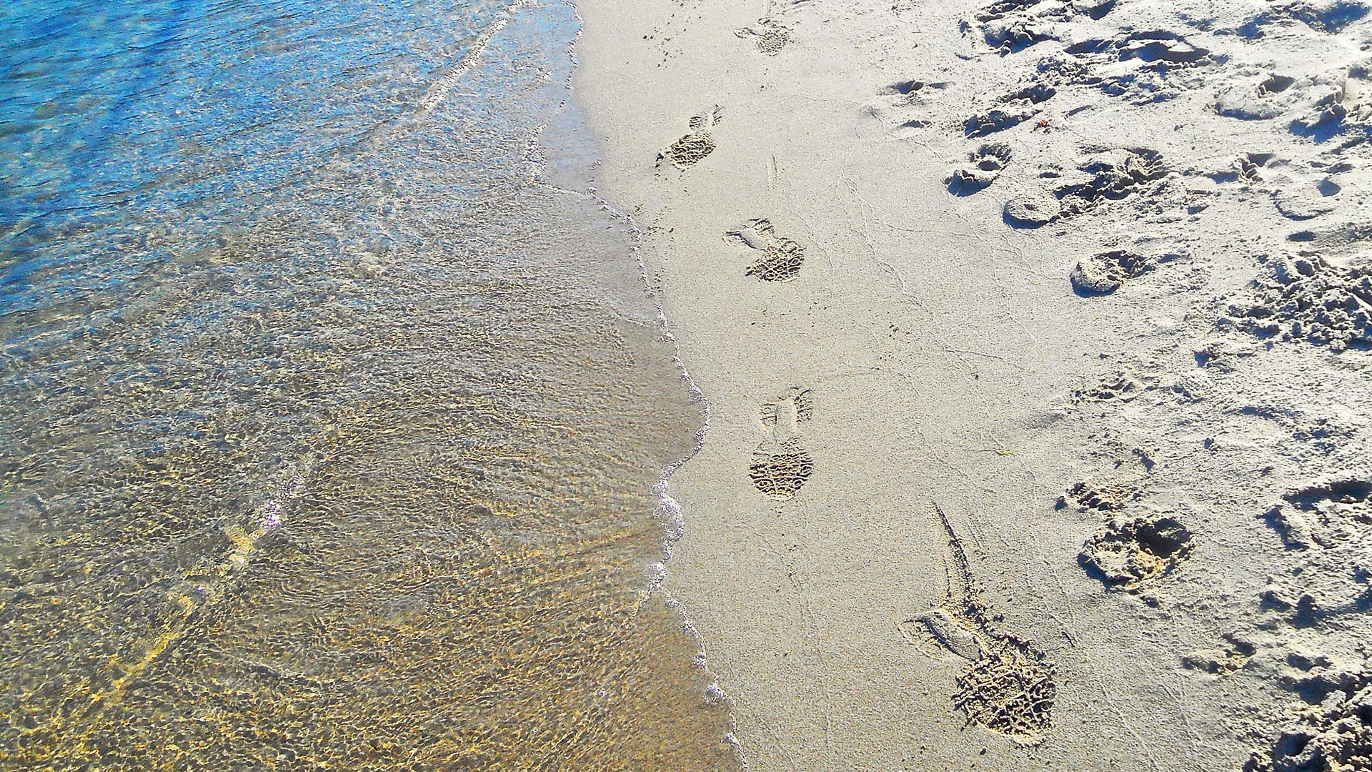 Fotspår på sandstrand. 