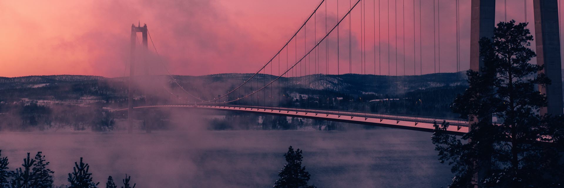 Photographer: Anders Jildén
Agency: Unsplash Höga kusten bro en vinterkväll med rök i luften