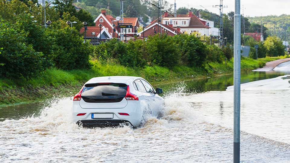 En bil på en översvämmad väg