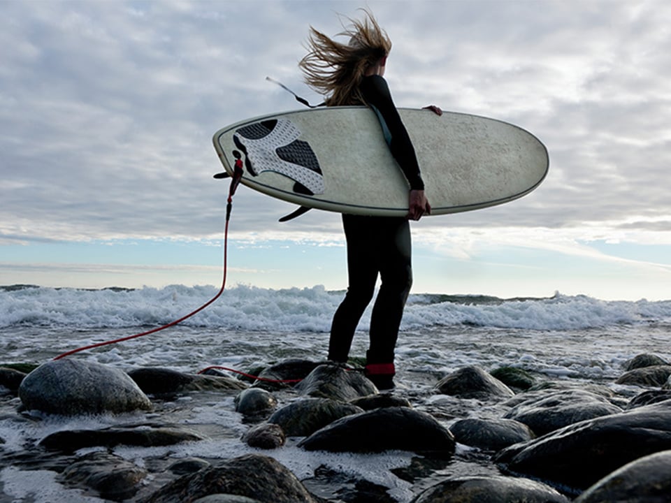 Person på strand med surfbräda