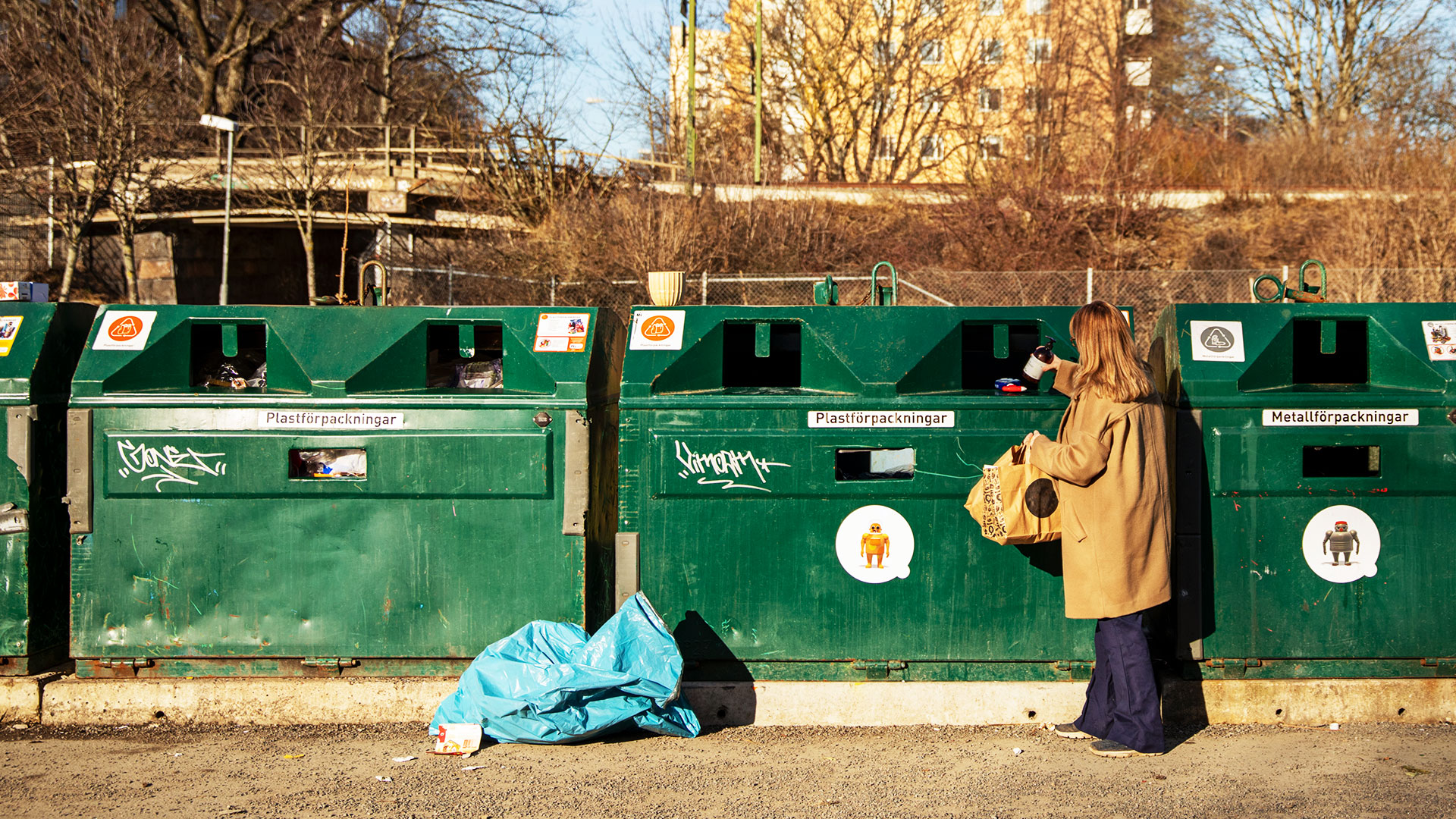 Kvinna slänger skräp i återvinningskärl, Solna