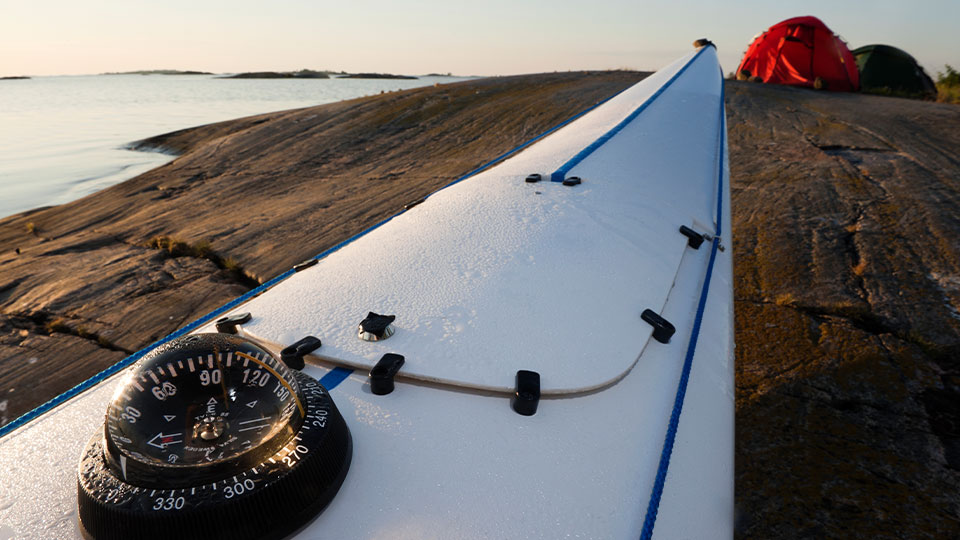 Fotograf: Fredrik Schlyter
Bildbyrå: Johnér / RF Kompass och fören på en kajak på en klipphäll med tält.